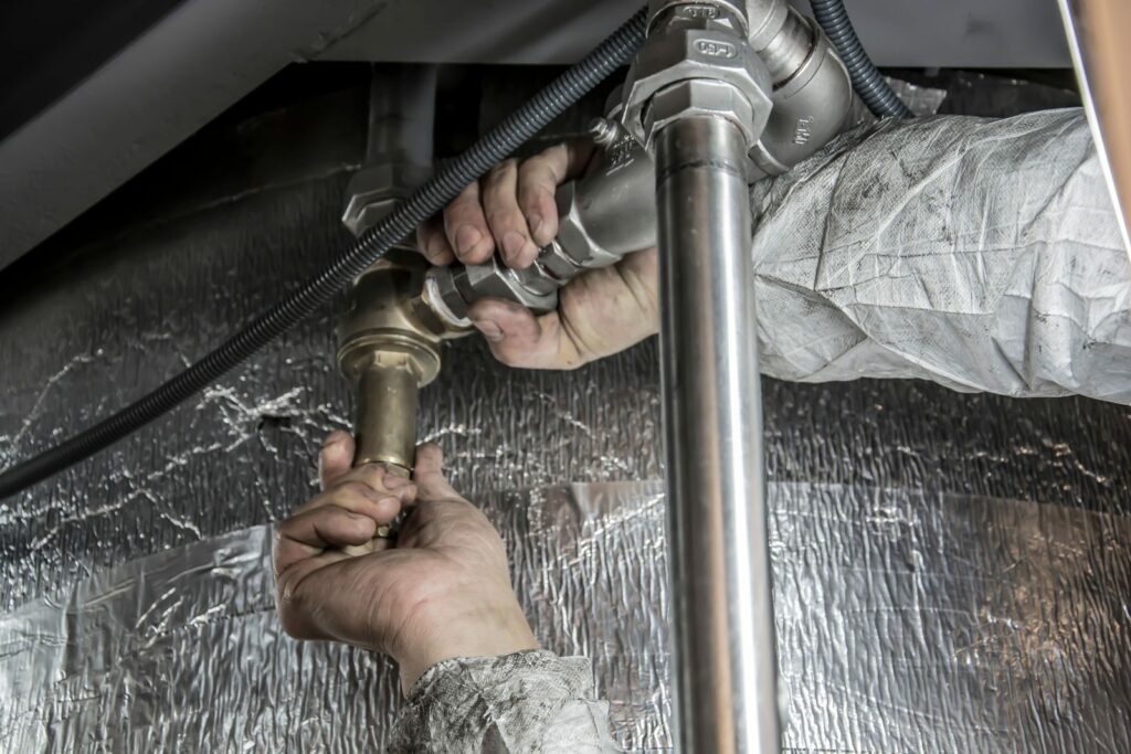 Technicien intervenant sur un circuit d’eau et des raccords