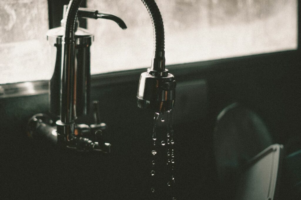 Gouttes d’eau sous un robinet en gros plan